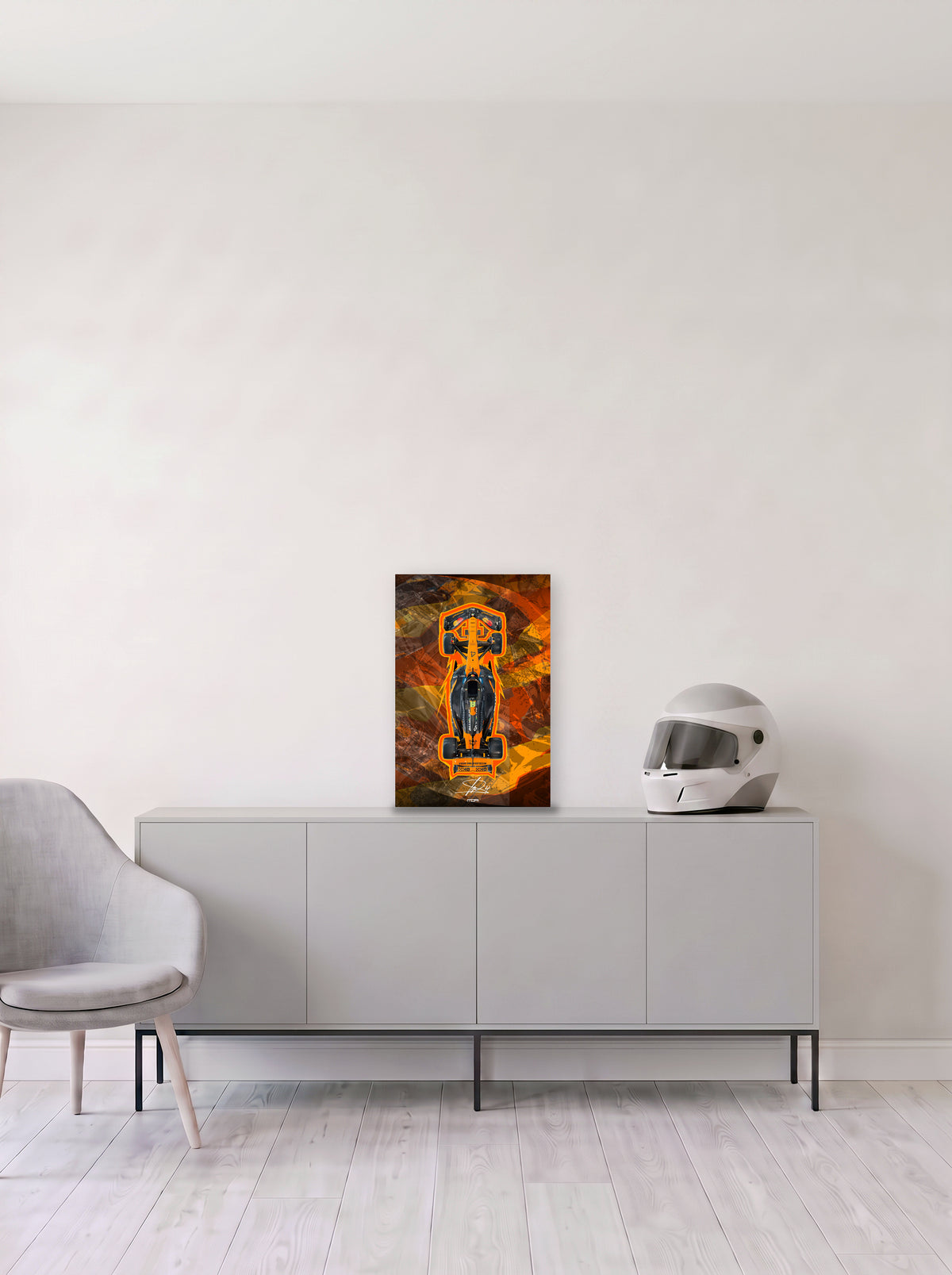 Poster del McLaren de Lando Norris perfilado en naranja sobre fondo abstracto, en medida 33,3 x 50 cm, apoyado sobre un aparador gris junto a un casco de competicion, decoracion racing de MOA-Grafics.