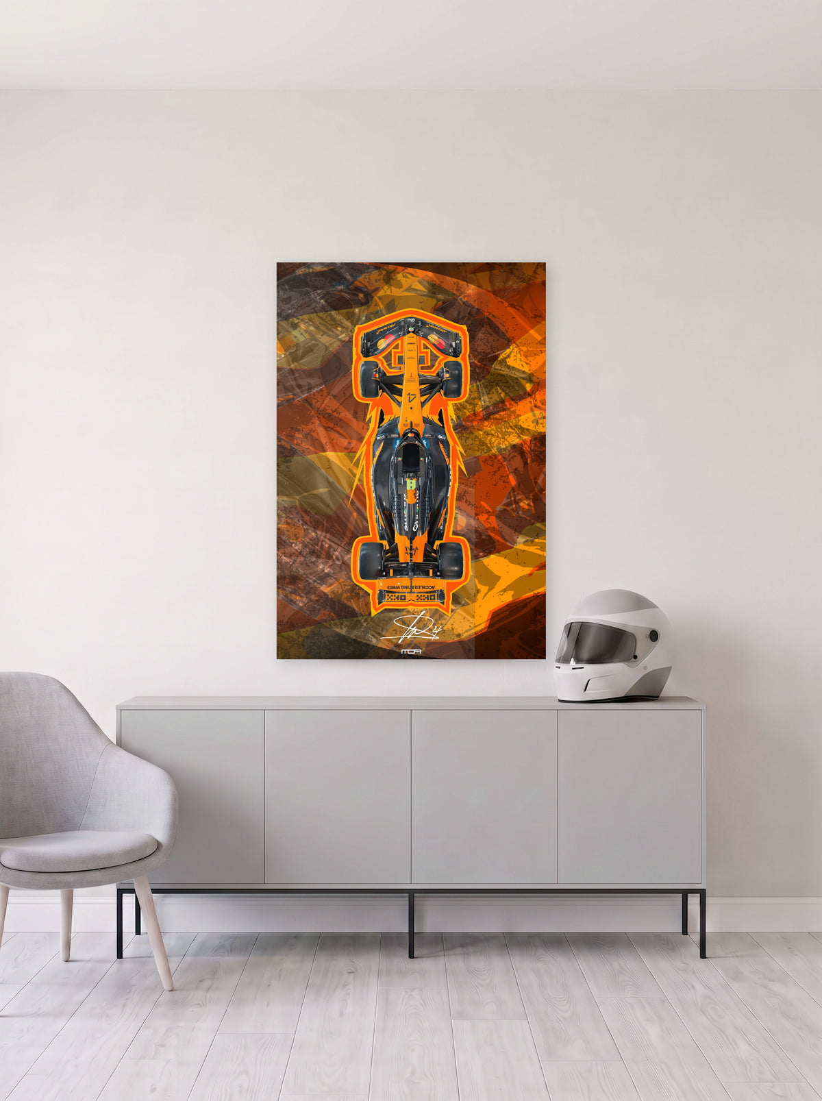 Poster del McLaren de Lando Norris perfilado en naranja sobre fondo abstracto, colgado en la pared clara de un salon, sobre un aparador gris con un casco de competicion al lado, decoracion racing de MOA-Grafics.