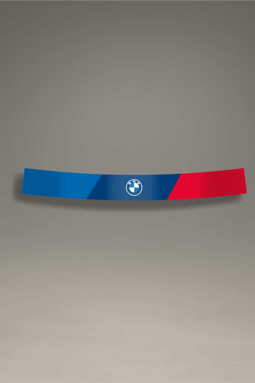 Parasol de vinilo para parabrisas de coche con diseño de franjas deportivas en azul y rojo, centrado con el logo circular de BMW. Ideal para personalización estética y reducción del brillo solar en coches BMW.