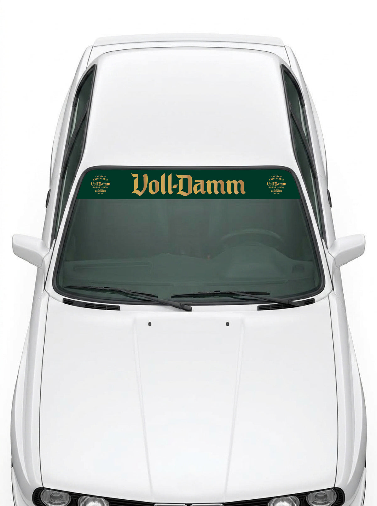 Coche con el parasol de vinilo Voll-Damm verde con el lettering en dorado y los sellos de la edicion 70 aniversario a los dos lados instalado en el parabrisas