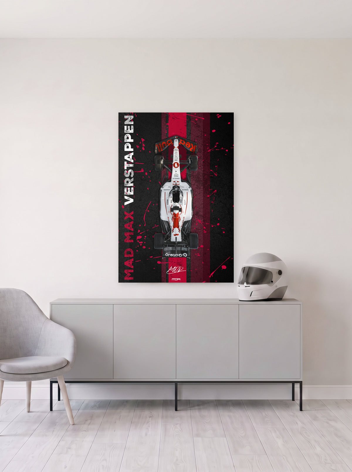 Poster del Red Bull de Max Verstappen con el rotulo Mad Max en vertical sobre franja roja, colgado en la pared clara de un salon, sobre un aparador gris con un casco de competicion al lado, decoracion racing de MOA-Grafics.
