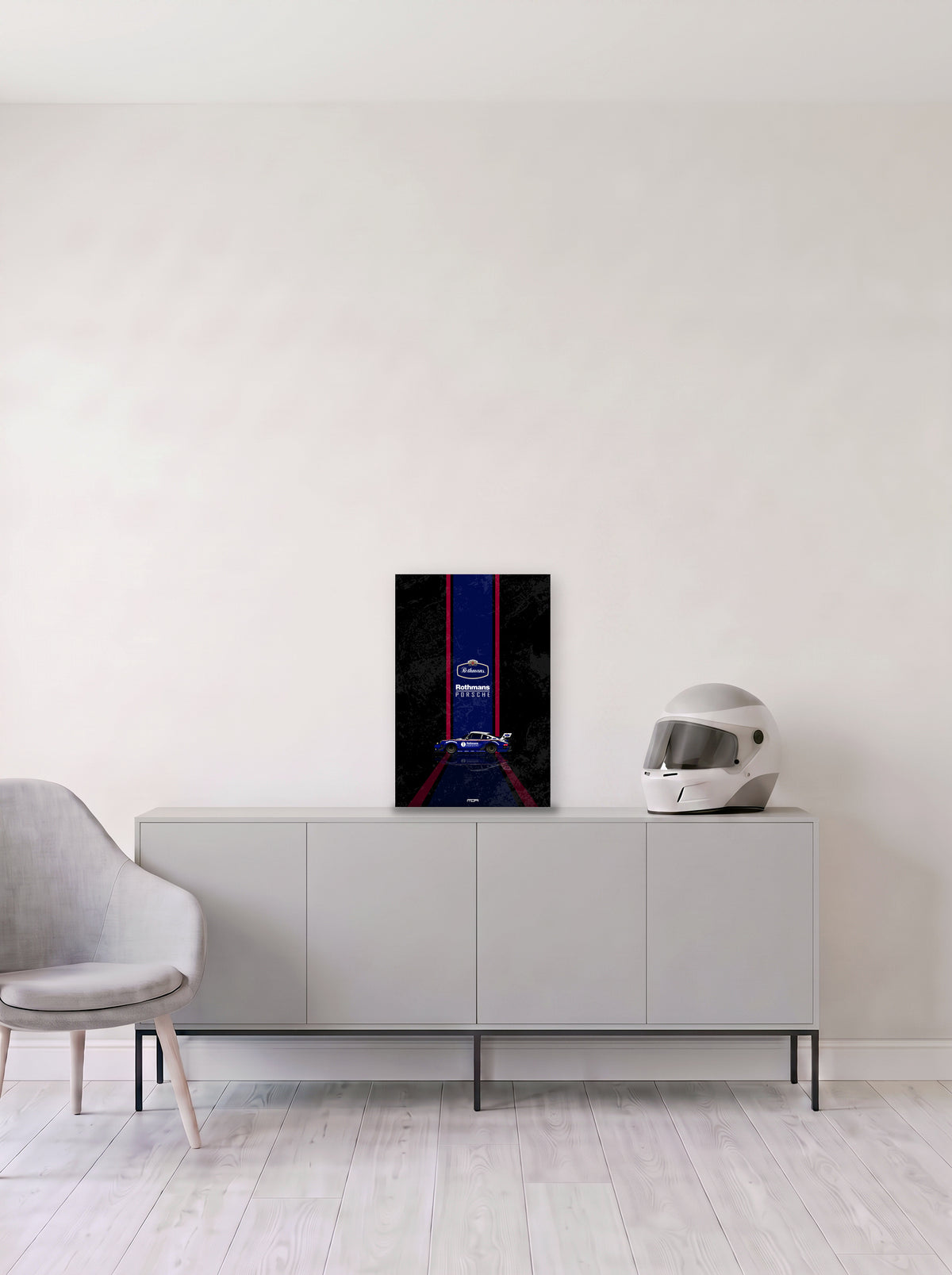 Poster del Porsche 911 Rothmans sobre fondo negro, en medida 33,3 x 50 cm, apoyado sobre un aparador gris junto a un casco de competicion, decoracion racing de MOA-Grafics.
