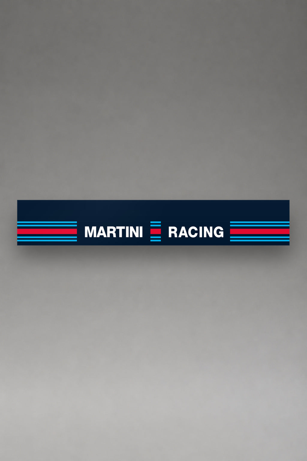 Parasol de vinilo Martini Racing azul marino con el lettering MARTINI RACING en blanco y los bloques de franjas a los lados, la tira entera vista de frente, de MOA-Grafics.