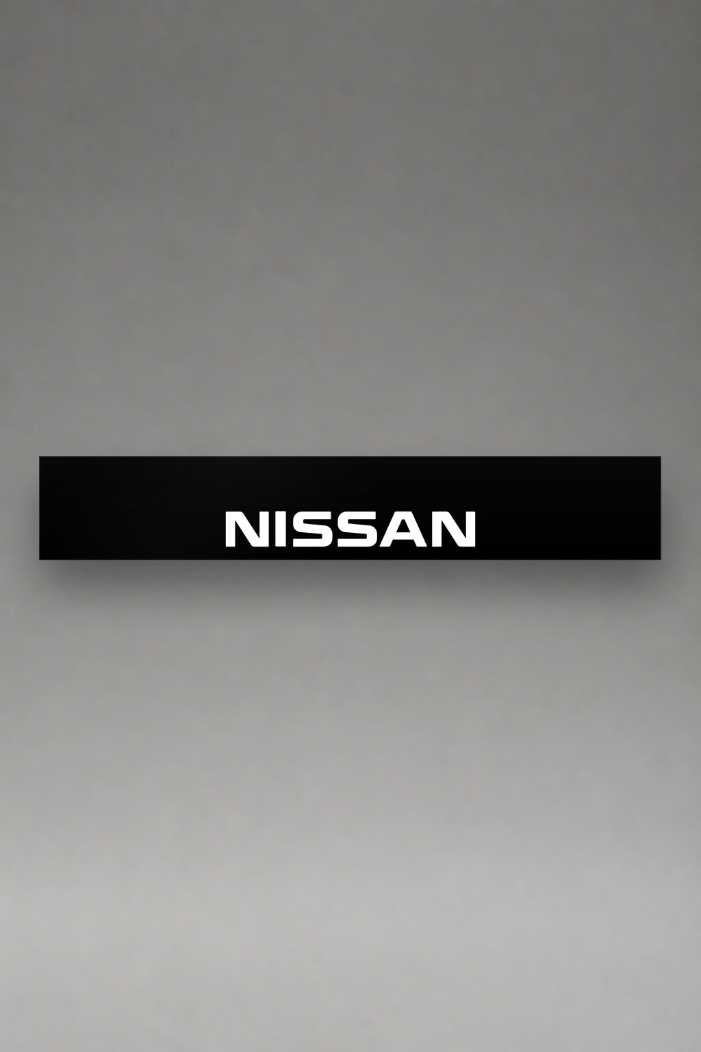 Parasol de vinilo Nissan negro con el logotipo NISSAN en blanco, la tira entera vista de frente, de MOA-Grafics.