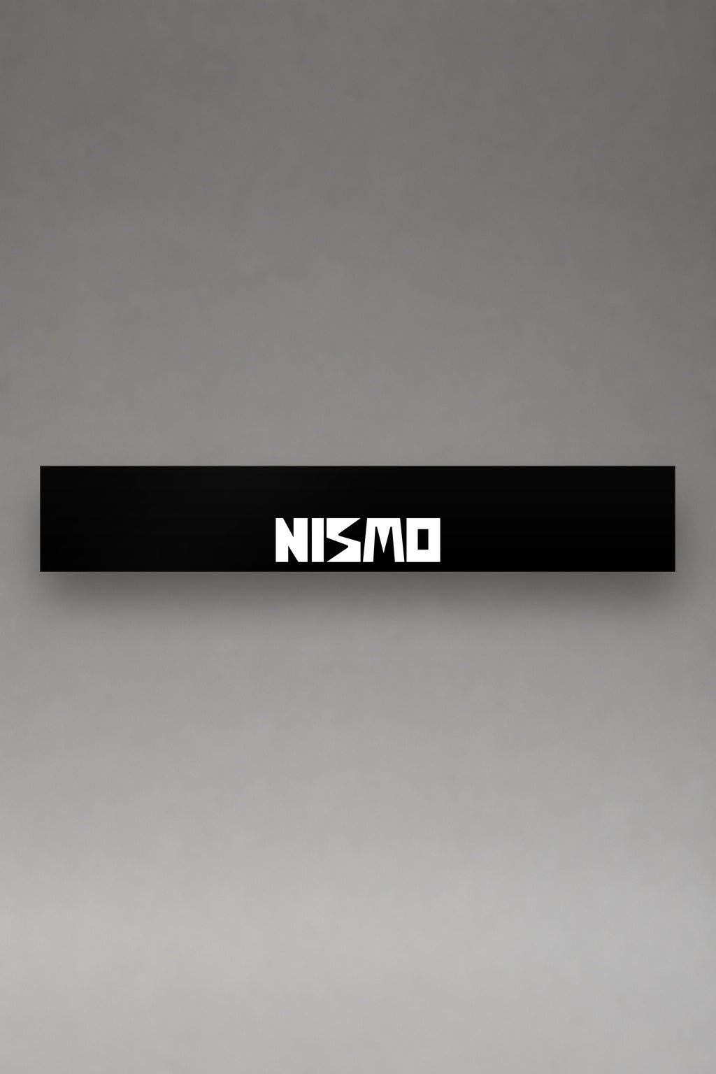 Parasol de vinilo Nissan NISMO negro con el lettering NISMO en blanco, la tira entera vista de frente, de MOA-Grafics.