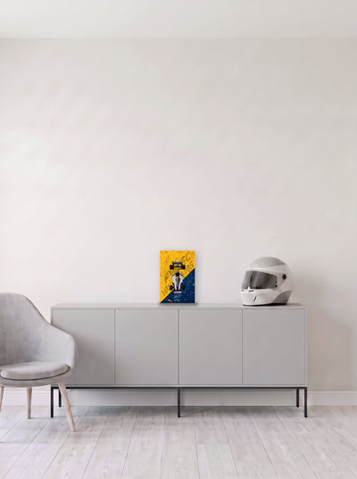 Poster del Williams FW15C de Alain Prost sobre fondo amarillo y azul, en medida 20 x 30 cm, apoyado sobre un aparador gris junto a un casco de competicion, decoracion racing de MOA-Grafics.