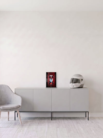Poster del McLaren MP4/6 de Ayrton Senna con salpicaduras sobre fondo rojo, en medida 20 x 30 cm, apoyado sobre un aparador gris junto a un casco de competicion, decoracion racing de MOA-Grafics.