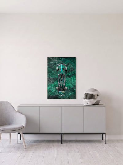 Poster del Aston Martin de Formula 1 de Fernando Alonso sobre fondo verde jaspeado, en medida 46,7 x 70 cm, colgado en la pared clara de un salon, sobre un aparador gris con un casco de competicion al lado, decoracion racing de MOA-Grafics.