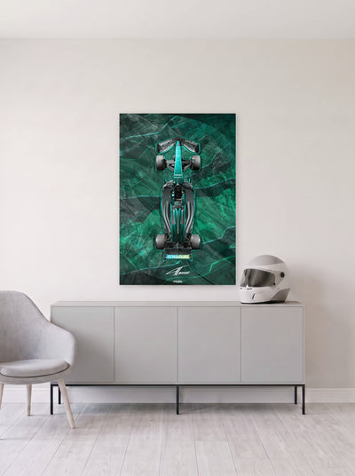 Poster del Aston Martin de Formula 1 de Fernando Alonso sobre fondo verde jaspeado, colgado en la pared clara de un salon, sobre un aparador gris con un casco de competicion al lado, decoracion racing de MOA-Grafics.