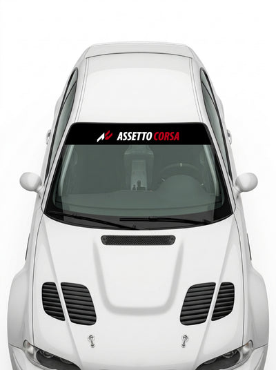 Coche con el parasol de vinilo Assetto Corsa negro con el lettering ASSETTO en blanco y CORSA en rojo instalado en el parabrisas