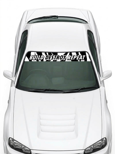 Coche con el parasol de vinilo negro con el lema BUILD DESTROY REPEAT en blanco y banderas a cuadros a los dos lados instalado en el parabrisas