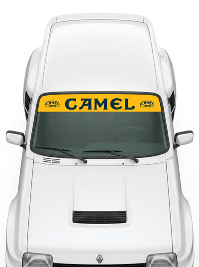 Coche con el parasol de vinilo Camel amarillo con el lettering CAMEL en negro y los sellos de la marca a los dos lados instalado en el parabrisas