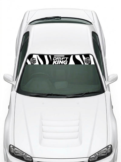 Coche con el parasol de vinilo Drift King con el estampado de cebra en blanco y negro y el lettering DRIFT KING instalado en el parabrisas