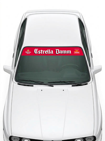 Coche con el parasol de vinilo Estrella Damm rojo con el lettering en blanco y los emblemas de la marca a los dos lados instalado en el parabrisas