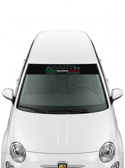 Parasol de vinilo Abarth Assetto Corse transparente con el lettering en verde y gris, instalado en el parabrisas de un Fiat 500 blanco