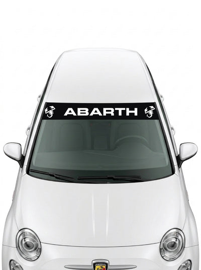 Parasol de vinilo Abarth negro con el lettering ABARTH en blanco y un escorpion a cada lado, instalado en el parabrisas de un Fiat 500 blanco