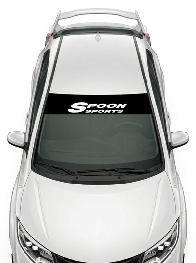 Parasol de vinilo Honda negro con el logotipo del preparador Spoon Sports en blanco, instalado en el parabrisas de un Honda Civic blanco