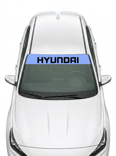Parasol de vinilo Hyundai azul con el lettering HYUNDAI en negro, instalado en el parabrisas de un Hyundai blanco