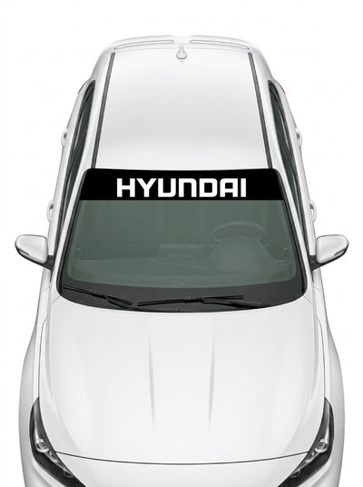 Parasol de vinilo Hyundai negro con el lettering HYUNDAI en blanco, instalado en el parabrisas de un Hyundai blanco
