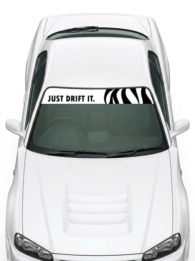 Coche con el parasol de vinilo Just Drift It blanco con el lettering JUST DRIFT IT en negro y el trazo cebra a la derecha instalado en el parabrisas