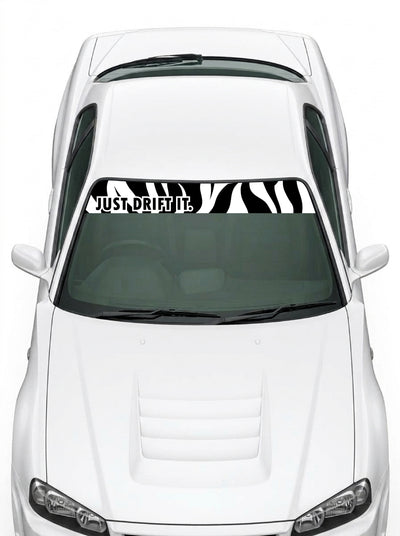 Coche con el parasol de vinilo Just Drift It negro con el lettering JUST DRIFT IT en blanco y el trazo cebra a la derecha instalado en el parabrisas
