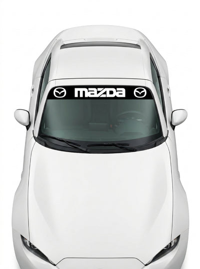 Coche con el parasol de vinilo Mazda negro con el lettering MAZDA entre dos emblemas ovales en blanco instalado en el parabrisas