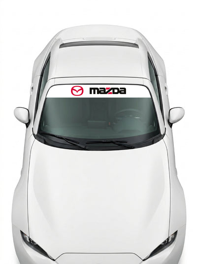 Coche con el parasol de vinilo Mazda blanco con el emblema oval en rojo y el lettering MAZDA en negro instalado en el parabrisas