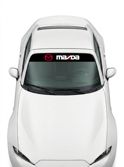 Coche con el parasol de vinilo Mazda negro con el emblema oval en rojo y el lettering MAZDA en blanco instalado en el parabrisas