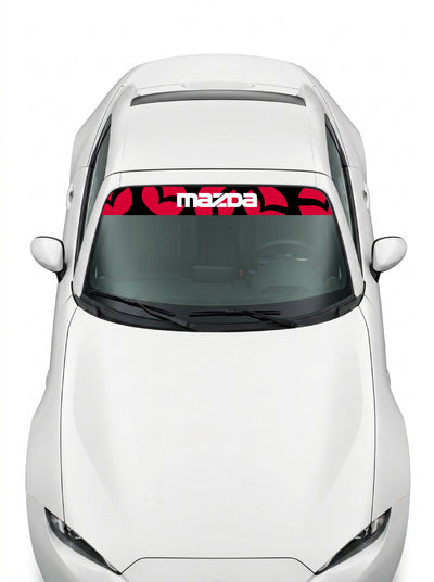 Coche con el parasol de vinilo Mazda con un patron de emblemas Mazda en rojo sobre negro y el lettering MAZDA en blanco instalado en el parabrisas
