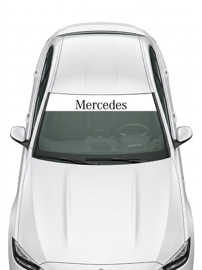 Coche con el parasol de vinilo Mercedes-Benz blanco con el lettering Mercedes en negro instalado en el parabrisas