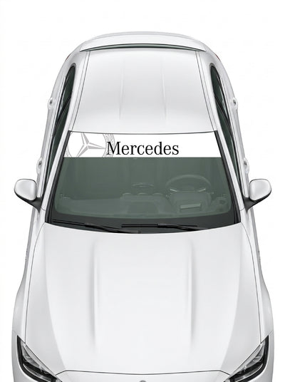 Coche con el parasol de vinilo Mercedes-Benz blanco con la estrella de tres puntas y el lettering Mercedes en negro instalado en el parabrisas