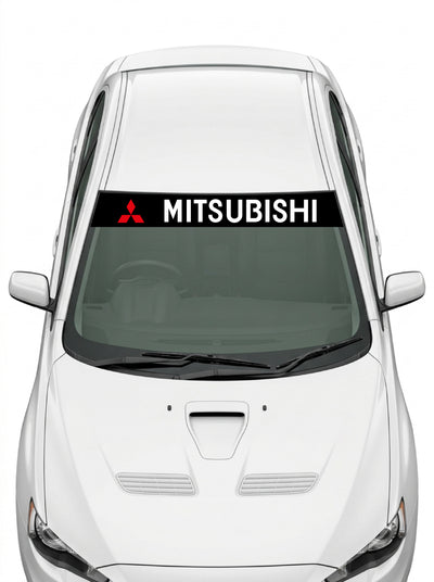 Coche con el parasol de vinilo Mitsubishi negro con el emblema de tres diamantes y el lettering MITSUBISHI en blanco instalado en el parabrisas