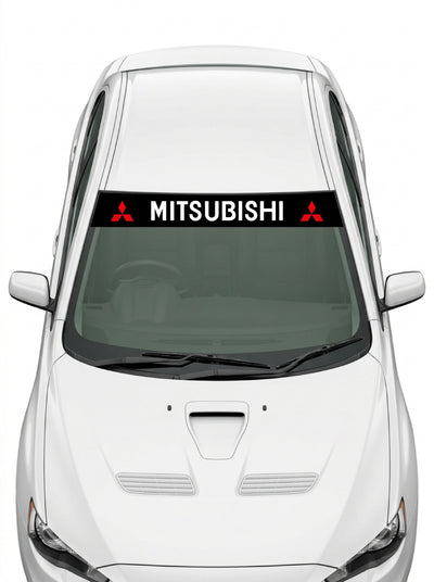 Coche con el parasol de vinilo Mitsubishi negro con el lettering MITSUBISHI en blanco y un emblema de tres diamantes a cada lado instalado en el parabrisas