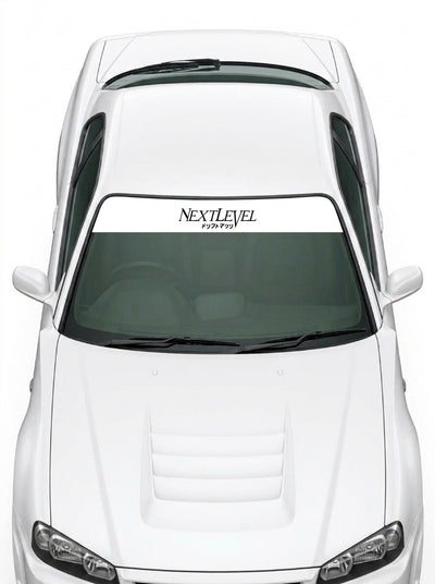 Coche con el parasol de vinilo NextLevel blanco con el lettering NEXTLEVEL en negro y los katakana de drift matsuri instalado en el parabrisas