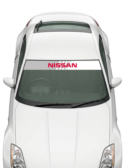 Coche con el parasol de vinilo Nissan blanco con el lettering NISSAN en rojo y lineas de velocidad instalado en el parabrisas
