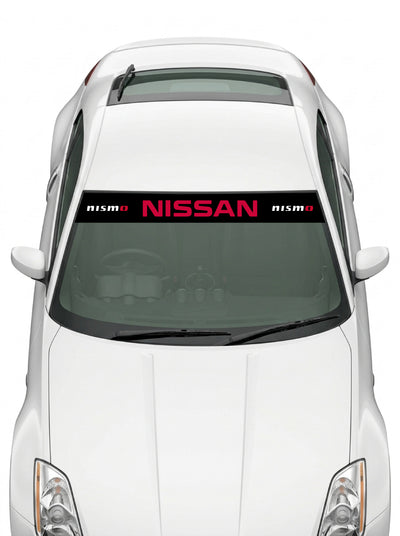 Coche con el parasol de vinilo Nissan negro con el lettering NISSAN en rojo y el logo NISMO a cada lado instalado en el parabrisas