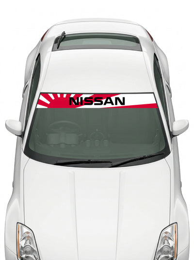 Coche con el parasol de vinilo Nissan blanco con el sol naciente en rojo y el lettering NISSAN en negro instalado en el parabrisas