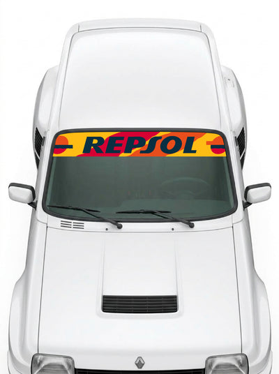 Coche con el parasol de vinilo con la livrea Repsol en naranja, amarillo y rojo y el lettering REPSOL instalado en el parabrisas