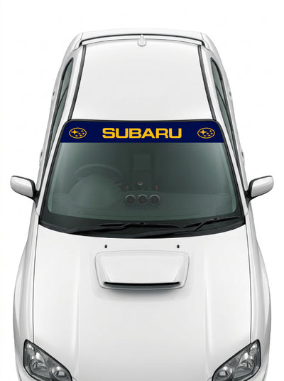 Coche con el parasol de vinilo Subaru azul marino con el lettering SUBARU en naranja y el emblema ovalado de las Pleyades a los dos lados instalado en el parabrisas