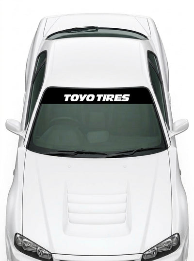 Coche con el parasol de vinilo Toyo Tires negro con el lettering TOYO TIRES en blanco instalado en el parabrisas