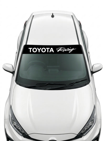 Coche con el parasol de vinilo Toyota negro con el lettering TOYOTA Racing en blanco y la palabra Racing manuscrita instalado en el parabrisas