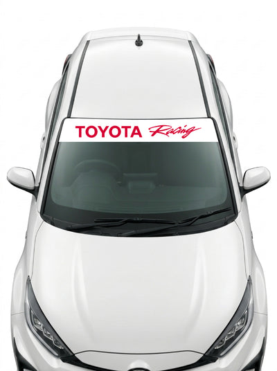 Coche con el parasol de vinilo Toyota blanco con el lettering TOYOTA Racing en rojo y la palabra Racing manuscrita instalado en el parabrisas
