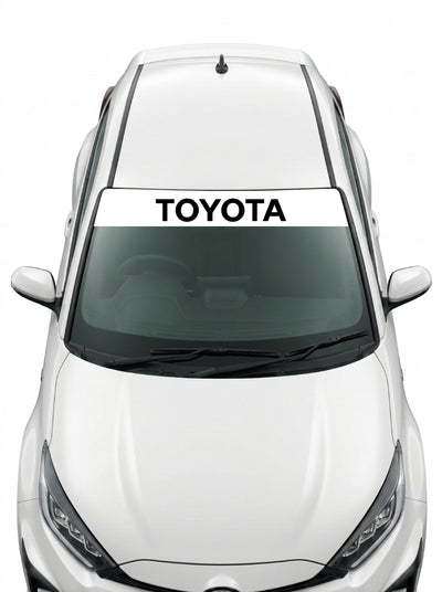 Coche con el parasol de vinilo Toyota blanco con el lettering TOYOTA en negro instalado en el parabrisas