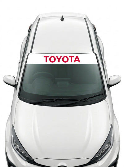 Coche con el parasol de vinilo Toyota blanco con el lettering TOYOTA en rojo instalado en el parabrisas