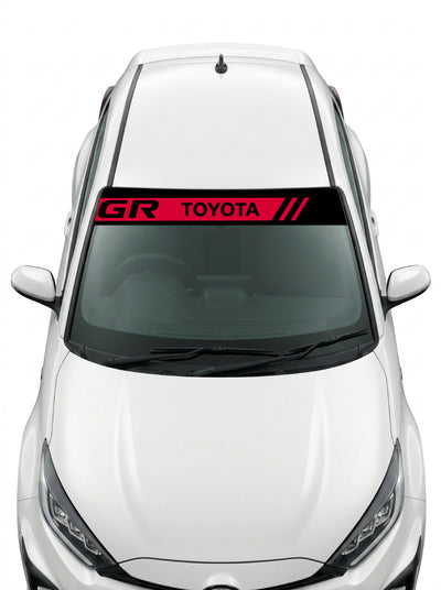 Coche con el parasol de vinilo Toyota negro con la banda roja, el lettering GR TOYOTA y las tres barras inclinadas instalado en el parabrisas