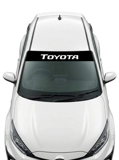 Coche con el parasol de vinilo Toyota negro con el lettering TOYOTA en blanco y tipografia italica estrecha instalado en el parabrisas