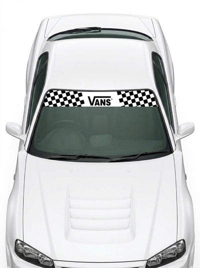 Coche con el parasol de vinilo Vans blanco con el lettering Vans en negro y bloques de damero a los dos lados instalado en el parabrisas