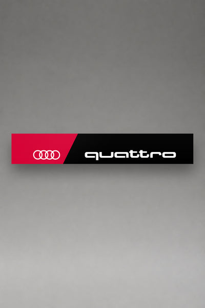 Parasol de vinilo Audi Quattro negro con la banda roja, los cuatro anillos y el lettering quattro en blanco, la tira entera de 150 x 25 cm vista de frente, de MOA-Grafics.