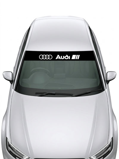 Parasol de vinilo Audi Sport de 150x25 cm en negro con los cuatro anillos junto al rotulo Audi, instalado en el parabrisas de un coche