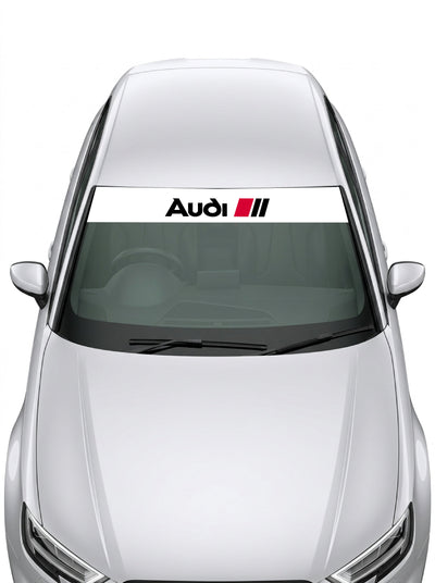 Parasol de vinilo Audi Sport de 150x25 cm en blanco con el rotulo Audi en negro y las tres barras rojas, instalado en el parabrisas de un coche